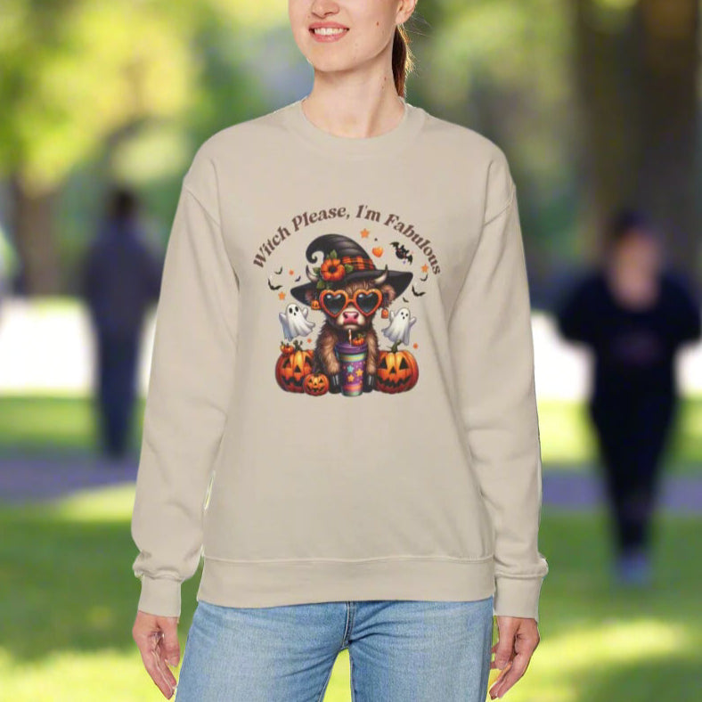 Woman wearing a light tan crewneck sweatshirt with "Witch Please, I'm Fabulous" text and Halloween-themed graphic featuring a cute witch character with hat, glasses, and colorful outfit surrounded by jack-o'-lanterns, ghosts, and autumn leaves