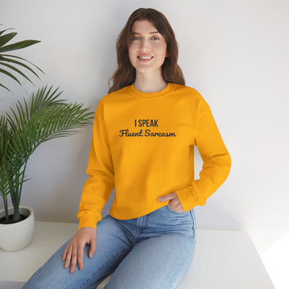 Woman wearing vibrant yellow crewneck sweatshirt with "I Speak Fluent Sarcasm" embroidered on chest in black lettering, styled with blue jeans in modern minimalist setting