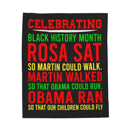 Large blanket with a black backgroup with red, green, and yellow writing: Celebrating Back History Month : Rosa Sat so Martin could walk Martin walked that Obama could run Obama ran So that our children could fly