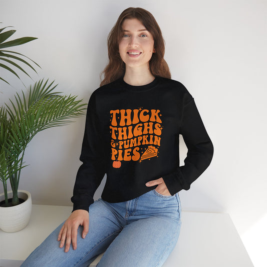 "Smiling woman wearing a black sweatshirt with orange text reading 'Thick Thighs &amp; Pumpkin Pies' and a pumpkin pie graphic – funny fall Thanksgiving crewneck"
