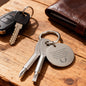 Personalized engraved screwdriver keychain set with flathead and Phillips head tools in silver stainless steel, displayed on wooden table next to car keys and leather wallet - custom multitool gift for men