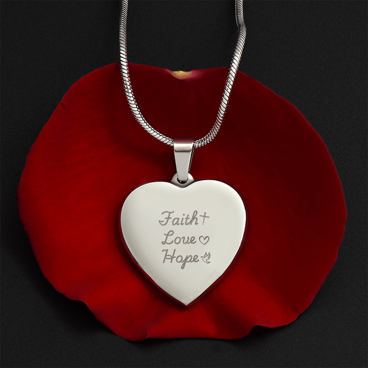Engraved heart necklace with Faith Love Hope inscription on polished stainless steel pendant displayed on a red rose, featuring an adjustable snake chain and personalized engraving option
