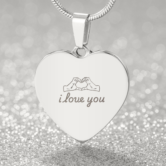 Engraved heart necklace pendant in polished stainless steel with i love you text and hand heart symbol on adjustable snake chain against sparkling silver background
