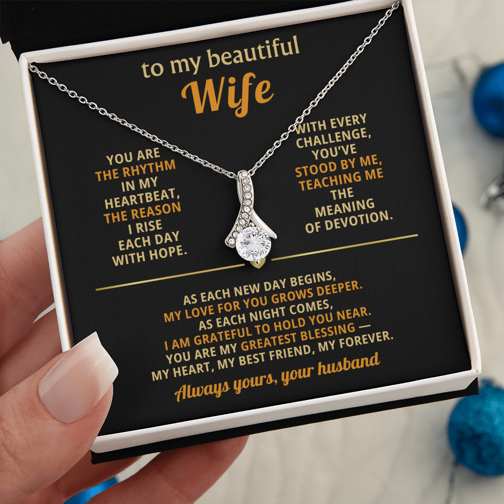 Alluring Beauty ribbon-shaped pendant necklace with a sparkling cubic zirconia stone displayed in a gift box for a wife.