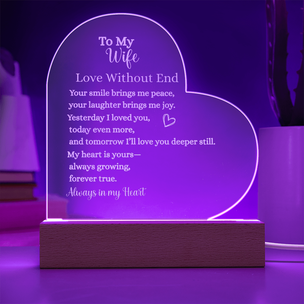 Heart-shaped engraved acrylic plaque with LED wooden base, glowing purple light, featuring romantic “To My Wife – Love Without End” message about everlasting love.