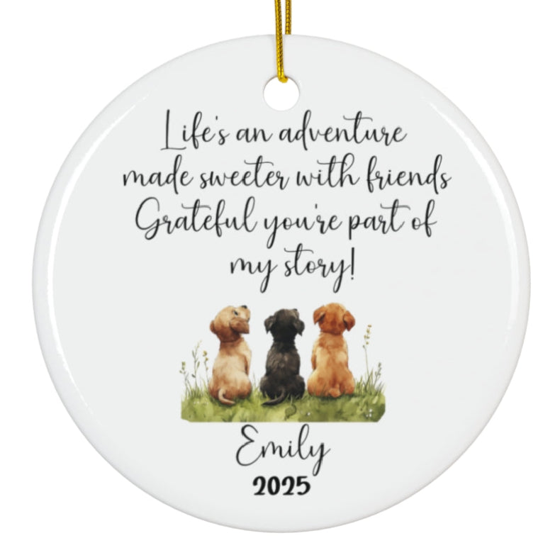 White ceramic Christmas ornament with gold hanging string featuring "Life's an adventure made sweeter with friends Grateful you're part of my story!" text and watercolor illustration of three dogs sitting together, personalized with "Emily 2025"