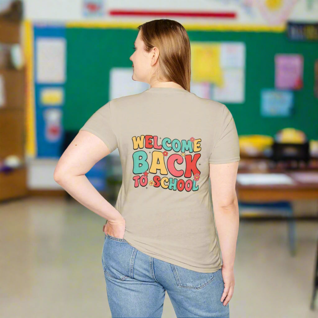 Person wearing a beige t-shirt with 'Welcome Back to School' text in colorful letters on a white background